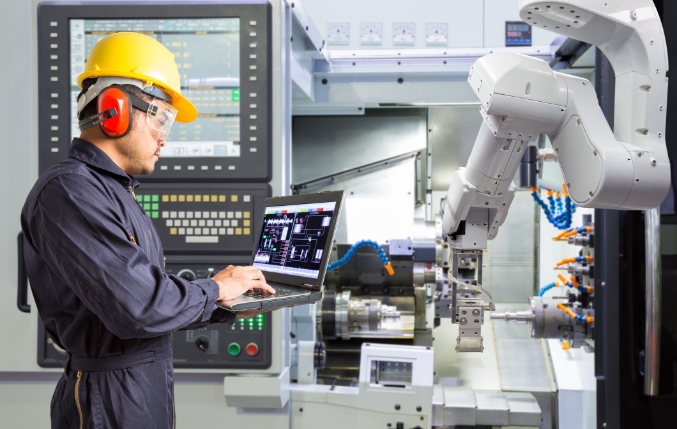 Custom Metal Design worker using a robotic arm